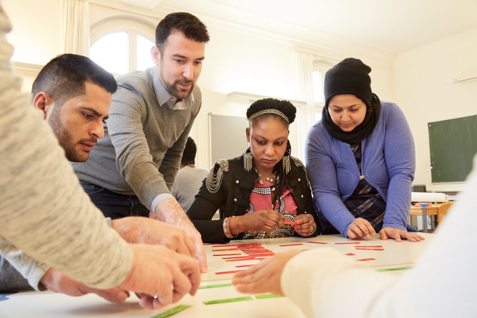 Course participants work with an instructor to arrange word cards on a table